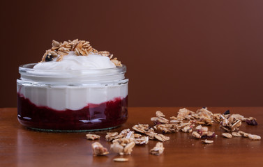 Plain greek yogurt and granola over raspberry jam as healthy breakfast