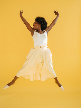 Black female jumping and smiling