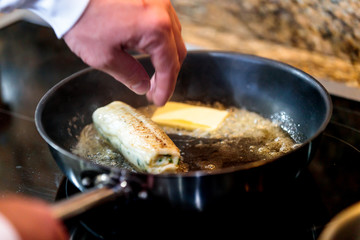 Closeup shot of the chef cooking a roll of fish in a roaster