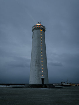 Lighthouse with light beam at dusk