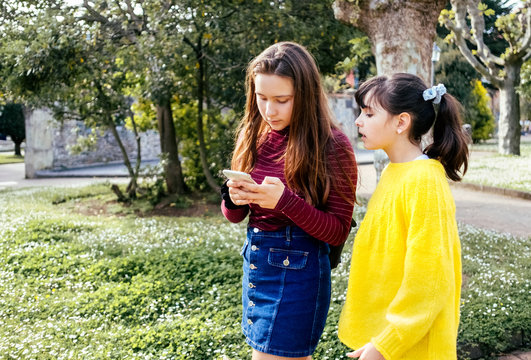 Two young girls using the smartphone