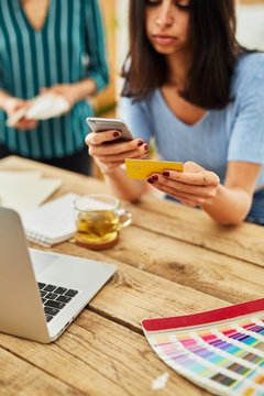 Young woman paying by mobile phone.