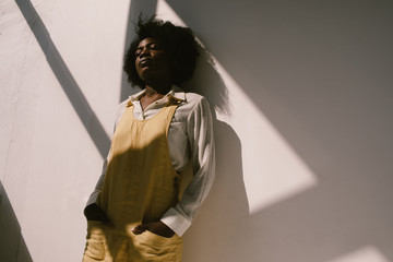 Dreamy black woman near concrete wall