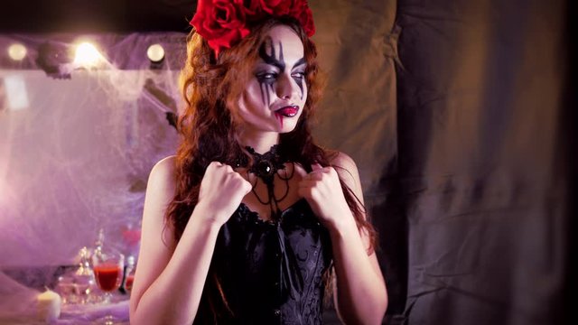 Easy Halloween Makeup. The girl with the picture on her face. The devil's bride with a wreath of red flowers on her head. The woman is wearing a black corset dress. The girl making goo-goo eyes and sh