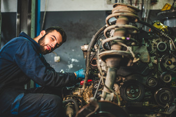 Fototapeta na wymiar Car service and maintenance: an automechanic is repairing a vehicle