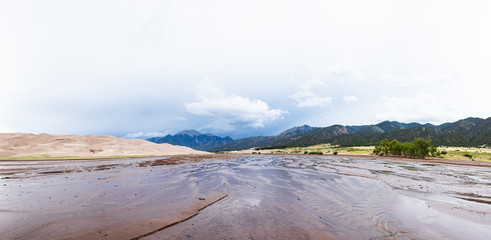A river flows past dunes