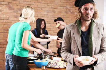 Homeless man with food received from volunteers
