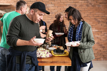 Volunteers giving food to homeless people