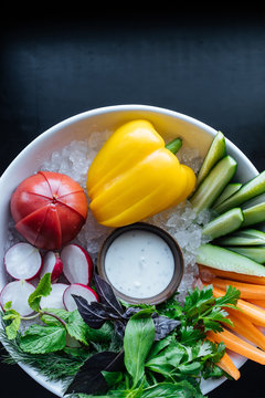 Different vegetables in bowl with sauce and ice