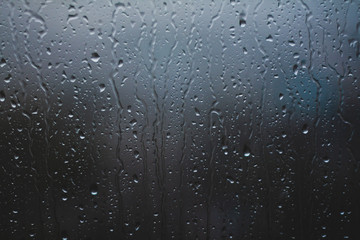Glass rainy window texture. Raindrops on the window glass bokeh.  Condensation. Wet glass. Rain drops on the window.