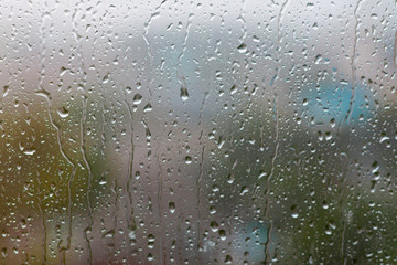 Glass rainy window texture. Raindrops on the window glass bokeh.  Condensation. Wet glass. Rain drops on the window.
