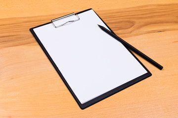 pen on blank white document sheet on wood clipboard on white wood table top view space