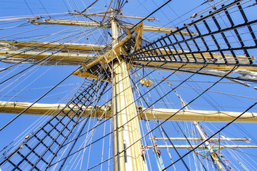 Fototapeta premium Upwards view of an old ship's masts. Old sailing ship mast. Rigging and mast of old ship.