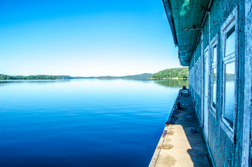 Morning on the Ladoga Lake. Mirror summer lake with an old house. Karelia, Russia