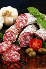 thinly sliced salami on a wooden texture on the background.