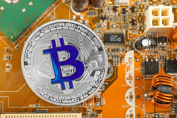 Silver bitcoin on PC circuit board