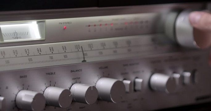 Vintage radio receiver and amplifier with fm scale. Tuning Analog Radio Frequency on Scale of the Vintage Receiver. Searching for stations on the old radio