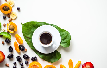 Creative layout of fresh summer fruits and coffee on a white background with space for text. 