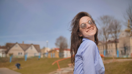 Beautiful 17 year old girl posing outdoors against the blue sky.