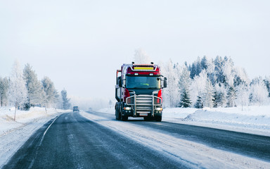 Winter road with snow. Truck in Finland. Lorry car and cold landscape of Lapland. Europe forest....