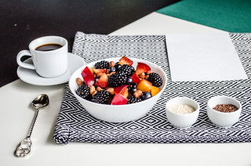 Creative layout  of a Yummy breakfast. A composition of fresh summer fruits, muesli, grains, plums on a cutting board and tablecloth. Yummy food. Top view with space for text.