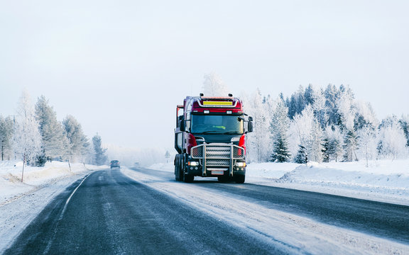 Winter road with snow. Truck in Finland. Lorry car and cold landscape of Lapland. Europe forest. Finnish City highway ride. Roadway and route snowy street trip. Delivery in downhill driveway driving