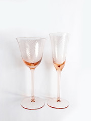Two clean new pink glasses for champagne or wine on a white background. Dishes for a party or celebration.