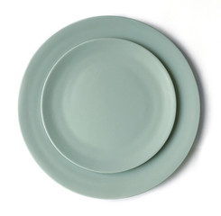 New luxury cutlery view from above on a isolated white background. Top view. Porcelain two green saucer. Trendy plate pastel shades. Flat lay view.