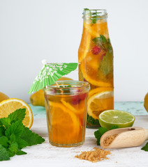 summer refreshing drink lemonade with lemons, cranberry, mint leaves, lime in a glass bottle