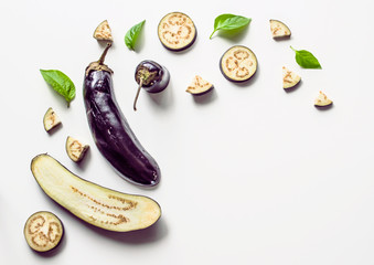 Creative layout from a solid and sliced ​​eggplant on a white background with space for text. Vegetables isolated on white background. View from above