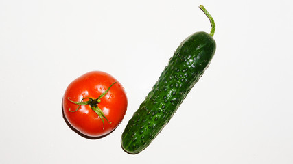 Bright green fresh cucumber and red ripe tomato on a white background. Isolated image with copy space. Close-up view from the top. Design template.