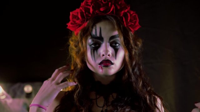 Easy Halloween Makeup. The girl with the picture on her face. The devil's bride with a wreath of red flowers on her head. The woman is wearing a black corset dress. The girl making goo-goo eyes and sh