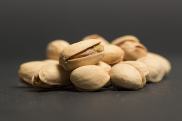 Puñado de pistachos sobre base y fondo negro
