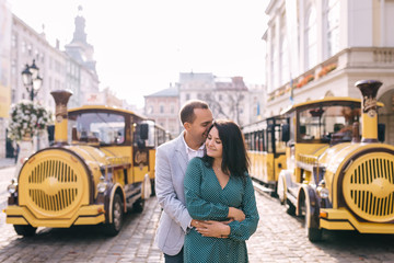 the guy hugs the girl from the back side near locomotive and wag