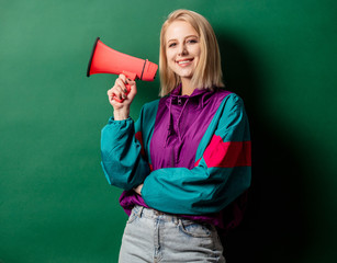 woman in 90s style punk jacket with loudspeaker on green background