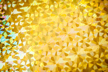 Shiny gold foil holiday wrapping paper  background with geometric pattern in full frame close-up