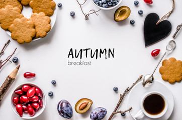 Breakfast. Autumn. Biscuits with coffee, fruit and berries on a white background.