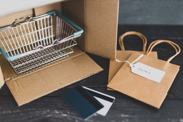 online shopping open parcel with shopping basket and bags and Sales price tags