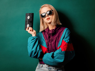 Style woman in 90s punk clothes wiith VHS cassette
