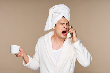 woman in bathrobe applying cream on her face