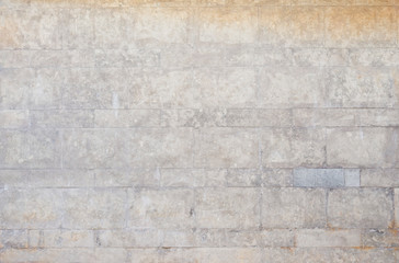 Old and weathered wall made of stone blocks. High resolution full frame textured background.