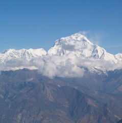 Amazing autumn panorama with mountains covered with snow and forest against the background of blue sky and clouds. Mount Everest, Nepal.