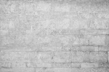 Old and weathered wall made of stone blocks in black and white. High resolution full frame textured background.