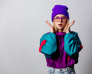 Blonde girl in 90s style jacket and hat with glasses