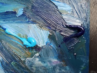 Artist’s palette for painting with oils. Macro photo of oil paints stains of various colors and tints. Colorful abstract background resembling oil painting texture on canvas.