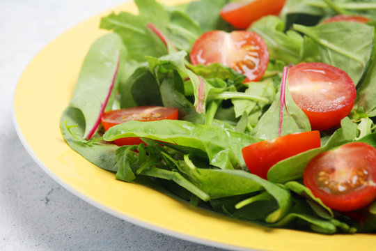 A plate with green salad and cherry tomatoes	