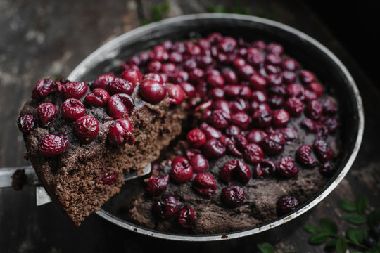 Close-up of cherry brownie pie slice over container on table