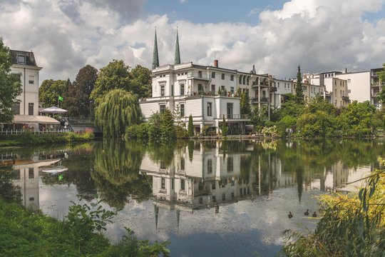 Buildings by Kr?henteich lake against cloudy sky in L?beck, Germany