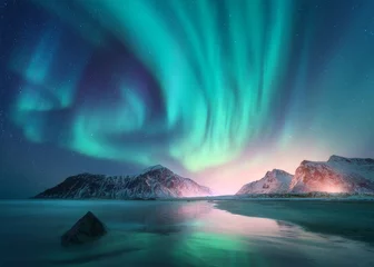 Keuken foto achterwand Aurora borealis over de zee en de besneeuwde bergen. Noorderlicht op de Lofoten-eilanden, Noorwegen. Hemel met poollichten en sterren. Winterlandschap met aurora, reflectie, zandstrand bij sterrennacht © den-belitsky