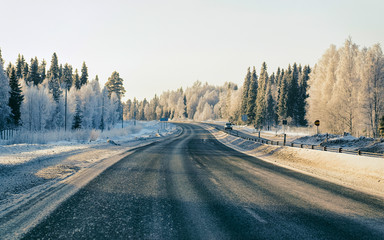 Car on Winter road with snow in Finland. Auto and Cold landscape of Lapland. Automobile on Europe...